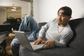 Man sitting on sofa using laptop. Royalty Free Stock Photo