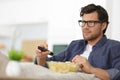 Man sitting on sofa watching tv and eating chips Royalty Free Stock Photo