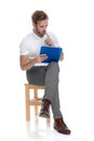 Man sitting and solving a difficul problem on his clipboard