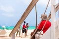 A man is sitting on the stairs against the sea in Punta Cana, La Altagracia, Dominican Republic. Copy space for text.