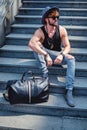 Man sitting on the staris with bag beside Royalty Free Stock Photo