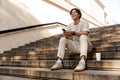 Man sitting on steps outdoors listening music using mobile phone. Royalty Free Stock Photo