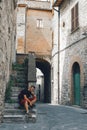 A man sitting on the steps. Tourist. Narni Terni, Umbria, Italy, medieval city: a typical old street. Vertical photo Royalty Free Stock Photo