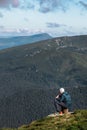 man sitting on the stump eating hiking food looking on mountains