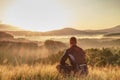 Man sitting on summit. He wear light clothes Royalty Free Stock Photo