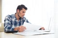 Man sitting at the table with bills and laptop Royalty Free Stock Photo