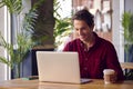 Man Sitting At Table In Coffee Shop Working On Laptop Computer Royalty Free Stock Photo