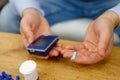 Man sitting at the table holding in his hands glucometer and stripes for checking blood sugar level, diabetes concept. Royalty Free Stock Photo