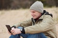 Man sitting with tablet on the winter beach Royalty Free Stock Photo