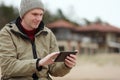 Man sitting with tablet on the winter beach Royalty Free Stock Photo