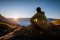 Man sitting on a top of mountain and watching the sunset Royalty Free Stock Photo