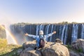 Man sitting on the top of a rock enjoying the Victoria Falls - Zimbabwe Royalty Free Stock Photo