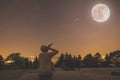 Man sitting under full moon at night with stars on the sky. Royalty Free Stock Photo