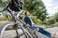 Man sitting in urban park with parked bicycle. Royalty Free Stock Photo
