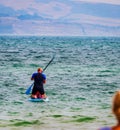 Man sitting and using paddle board in Weymouth beachfront England Royalty Free Stock Photo