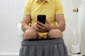 Man Sitting Using Smartphone In Toilet Royalty Free Stock Photo