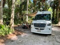 A man sitting beside a van at a campsite at Trimble Park in Mount Dora, Florida