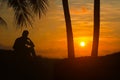 A man sitting and waiting to watching the sunrise on the coconut beach in the morning Royalty Free Stock Photo