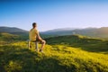 Man sitting on a wooden bench on a hill