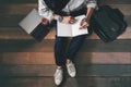 Man sitting on a wooden floor with glasses, briefcase, book, carrot juice, laptop are writing notepaper book working and reading Royalty Free Stock Photo