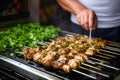 man skewering herb-marinated chicken for kebabs