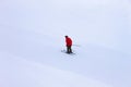 A man skier in a red jacket at snowy slope in mountains. Royalty Free Stock Photo