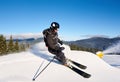 Man skiing on prepared slope with fresh snow. Snow gun machine making artificial snowfall. Magic nature on background. Royalty Free Stock Photo