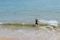 Man on a skimboard catching a wave in a beach in Aonang, Krabi, Thailand Royalty Free Stock Photo