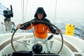 A man skipper drives the sailboat in the open sea. Yachting. Sailing.