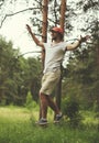 Man slacklining walking and balancing on a rope, slackline in forest