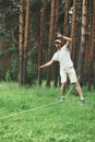 Man slacklining walking and balancing on a rope, slackline outdoors in forest Royalty Free Stock Photo