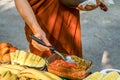 Man`slama hand with metal ladle spoon and soup in cauldron at background. Camping cooking Royalty Free Stock Photo