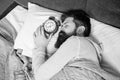 Man sleeping with alarm clock in bed, sleep time