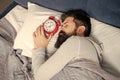 Man sleeping with alarm clock in bed, sleep time
