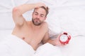 Man sleeping bed white bedclothes and red alarm clock, lack of sleep concept