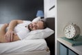 Man sleeping in his bedroom with alarm clock in foreground Royalty Free Stock Photo