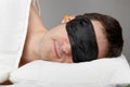 Man with Sleeping mask and earplugs in bed Royalty Free Stock Photo