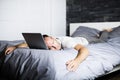 Man sleeping over laptop computer in bed Royalty Free Stock Photo