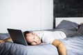 Man sleeping over laptop computer in bed Royalty Free Stock Photo