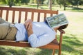 Man sleeping on park bench with newspaper over face Royalty Free Stock Photo