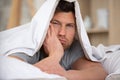 Man sleepy drowsy unshaven bearded face covered with blanket