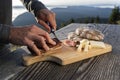 Man slice up delicious South Tyrolean smoked bacon and cheese with flat bread lying on a rustic table Royalty Free Stock Photo