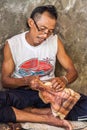 A man slices a wood figure