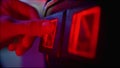 Man sliding a coin into the acceptor and playing an arcade game on the machine