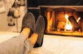 Man in slippers relaxing with his feet up with a fireplace in the background. Royalty Free Stock Photo