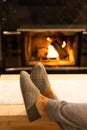 Man in slippers relaxing with his feet up with a fireplace in the background. Royalty Free Stock Photo