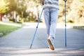 Man slowly walking in park while using sprinter sticks Royalty Free Stock Photo