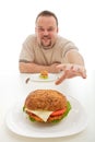 Man with small hamburger reaching for a bigger one Royalty Free Stock Photo