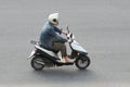 A man on a small moped in the city