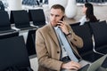 Man on smart phone - young business man in airport. Businessman using smartphone inside office building or airport. Royalty Free Stock Photo